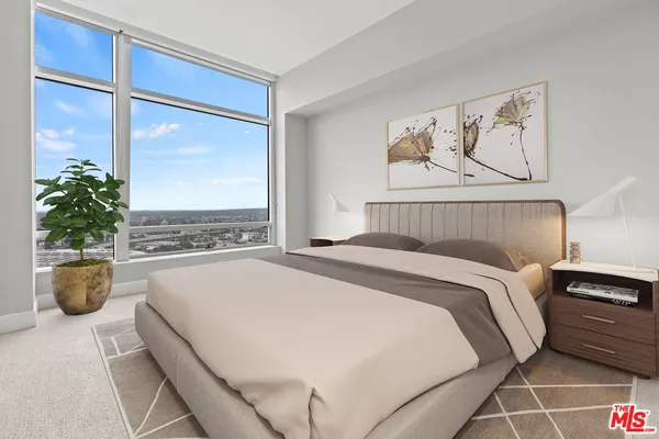 a bedroom with a large bed and a potted plant