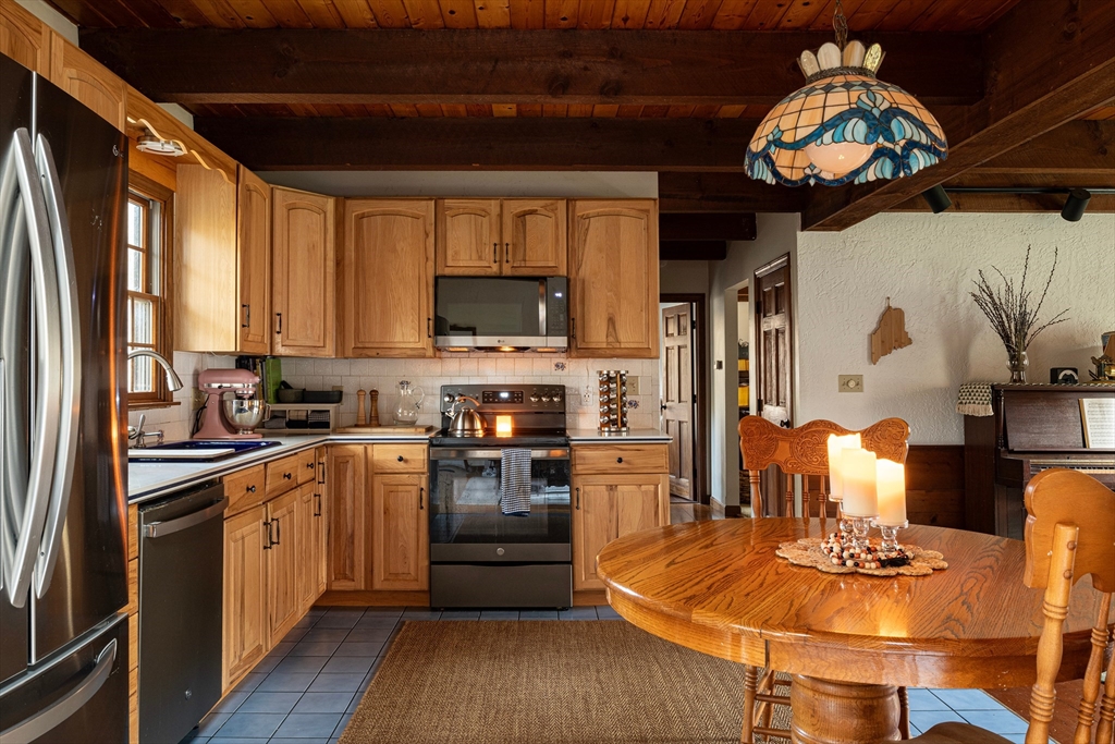 5 June Street Pepperell, MA 01463 - Photo 11 of 31 a kitchen with stainless steel appliances granite countertop a stove top oven a sink a dining table and chairs with wooden floor