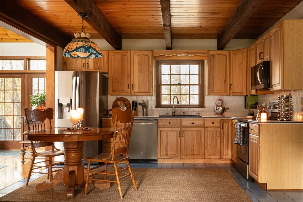 5 June Street Pepperell, MA 01463 - Photo 10 of 31 a kitchen with stainless steel appliances granite countertop a stove a refrigerator a sink dishwasher with a dining table and chairs