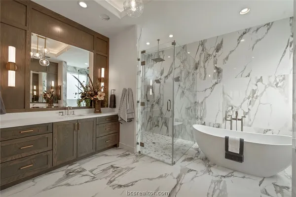 a spacious bathroom with a double vanity sink mirror and bathtub