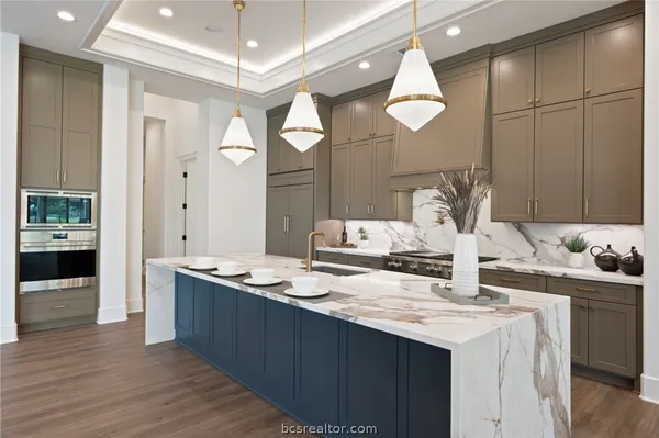 a large kitchen with stainless steel appliances granite countertop a lot of counter space and wooden floor