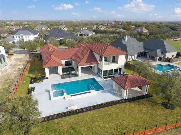 an aerial view of residential houses with outdoor space and a lake view