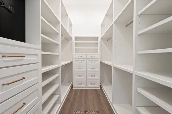 a view of walk in closet with empty racks