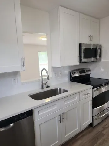 a kitchen with white cabinets and a sink