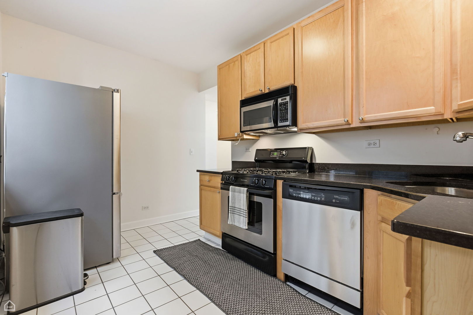 3222 West Berteau Avenue, Unit 2 Chicago, IL 60618 - Photo 14 of 16 a kitchen with stainless steel appliances granite countertop a stove a microwave and a refrigerator