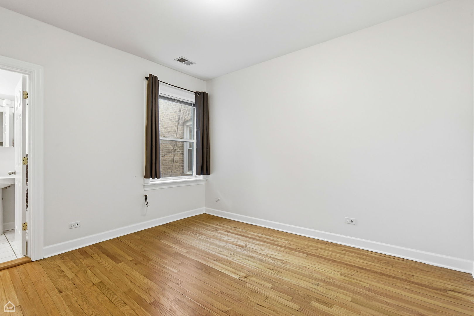 3222 West Berteau Avenue, Unit 2 Chicago, IL 60618 - Photo 5 of 16 a view of an empty room with wooden floor and a window