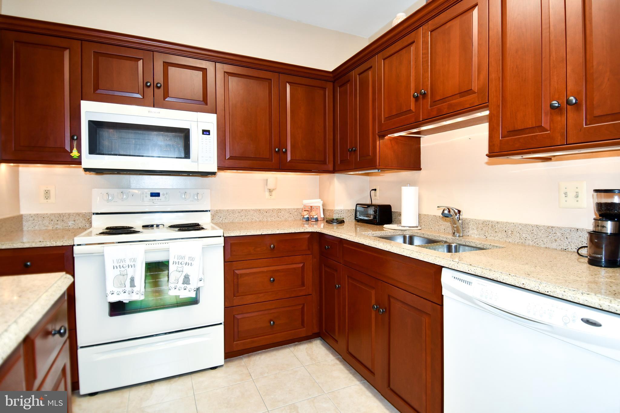 1250 South Washington Street, Unit 816 Alexandria, VA 22314 - Photo 16 of 58 a kitchen with stainless steel appliances granite countertop a stove microwave and cabinets