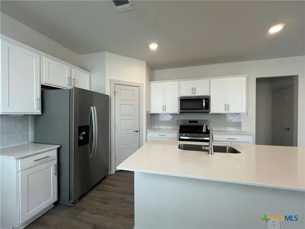a kitchen with a refrigerator stove and microwave