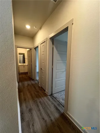 a view of a hallway with wooden floor