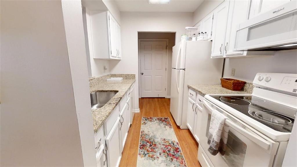 300 Johnson Ferry Road, Unit B605 Atlanta, GA 30328 - Photo 19 of 33 a kitchen with a sink a refrigerator and a stove