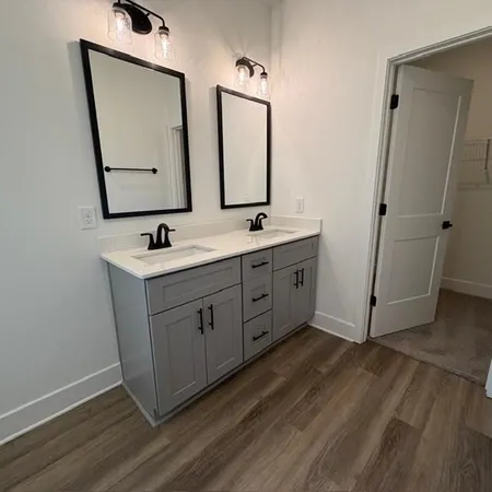 a bathroom with a double vanity sink and mirror