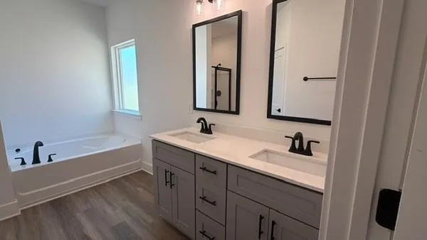 a bathroom with 2 sink tub and a mirror