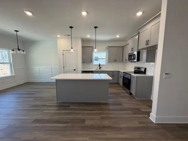 a large kitchen with kitchen island a sink stainless steel appliances and cabinets