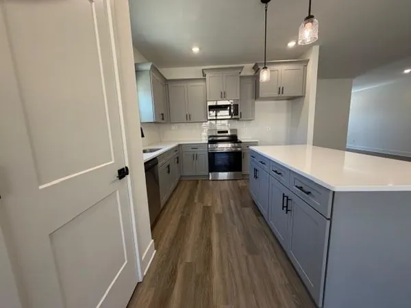 a large kitchen with a sink and refrigerator