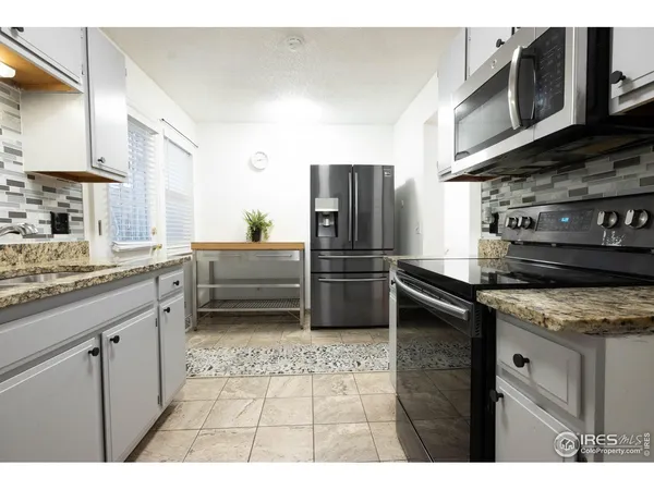 a kitchen with stainless steel appliances granite countertop a refrigerator and a stove