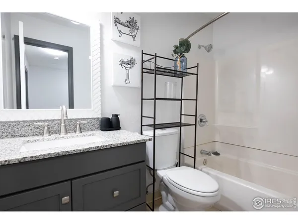 a bathroom with a granite countertop toilet sink and mirror