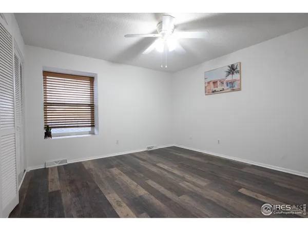 a living room with a wooden floor and a large window