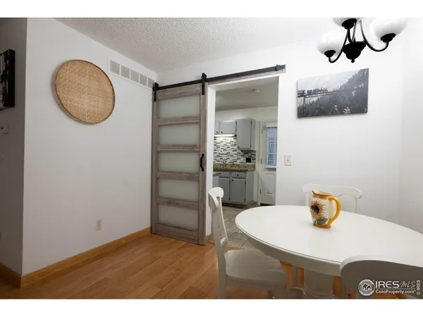 a room with a table chairs and a refrigerator