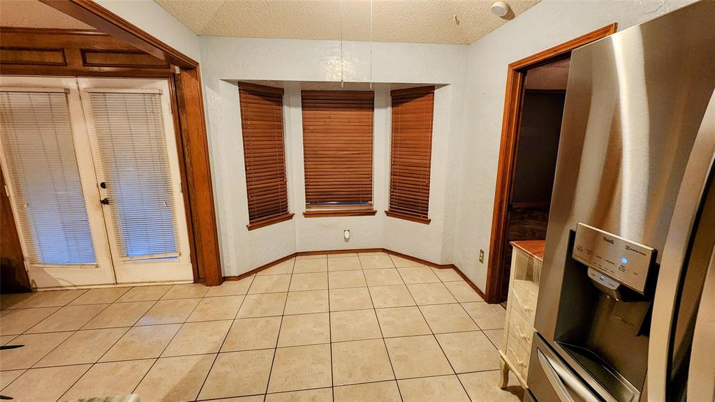 7505 Patsy Court Arlington, TX 76016 - Photo 11 of 38 Dining area featuring a textured wall and light tile patterned flooring.