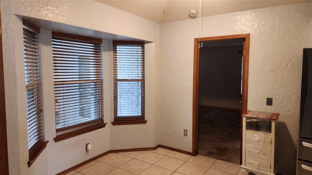 7505 Patsy Court Arlington, TX 76016 - Photo 12 of 38 Dining area featuring a textured wall and light tile patterned flooring.