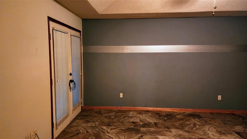 7505 Patsy Court Arlington, TX 76016 - Photo 17 of 38 Bedroom featuring dark stone finish tile floors. Door to Sunnroom.