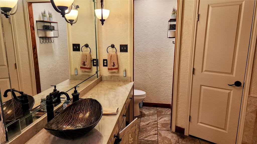 7505 Patsy Court Arlington, TX 76016 - Photo 19 of 38 Bathroom with vanity, a textured wall, with Jacuzzi jetted tub.