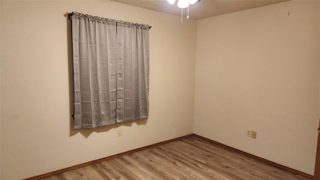 7505 Patsy Court Arlington, TX 76016 - Photo 25 of 38 Bedroom with light wood-style floors and baseboards.