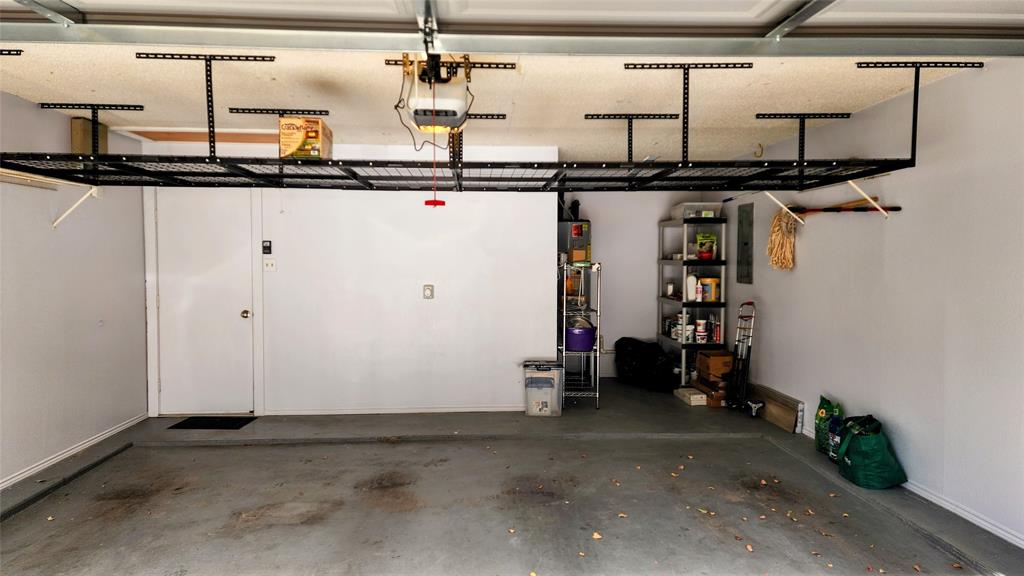7505 Patsy Court Arlington, TX 76016 - Photo 36 of 38 Garage featuring a garage door opener and overhead storage.