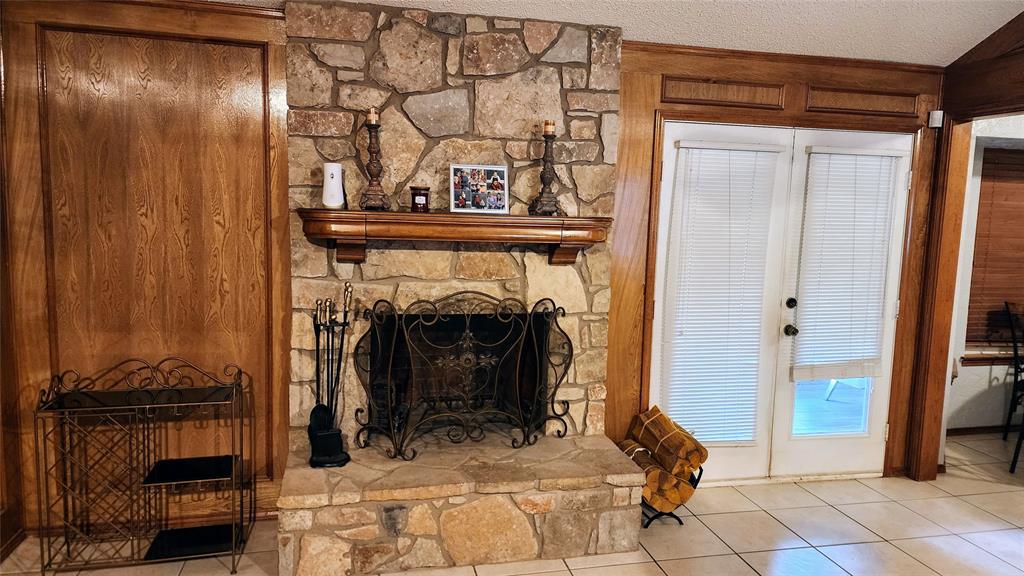 7505 Patsy Court Arlington, TX 76016 - Photo 7 of 38 Woodburning Fireplace in the Living area with french doors, and picture frame paneling walls.