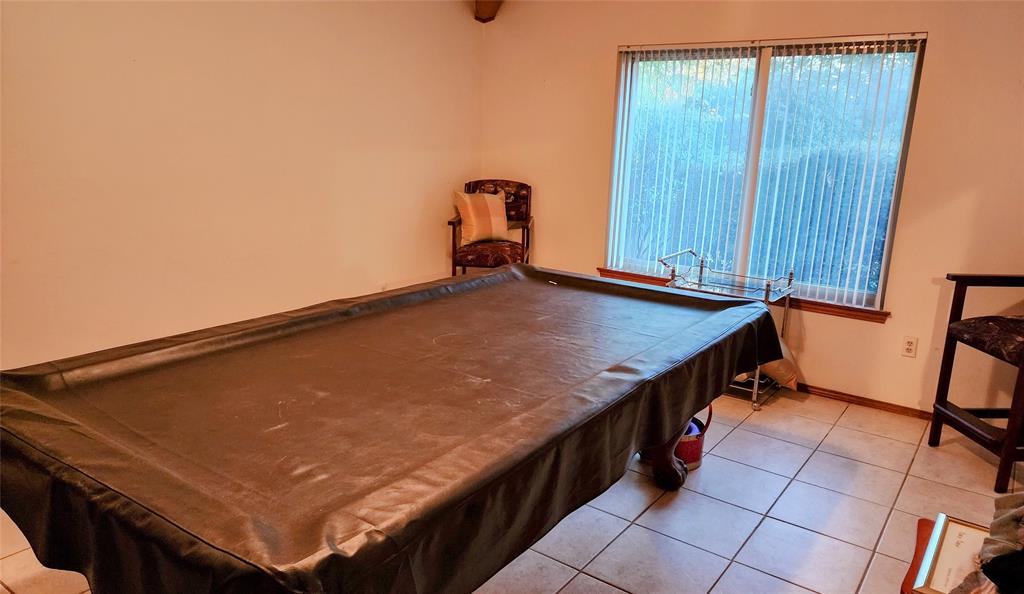 7505 Patsy Court Arlington, TX 76016 - Photo 8 of 38 Game Room with beamed ceiling, light tile patterned floors, built -in shelves, and included billiards table.