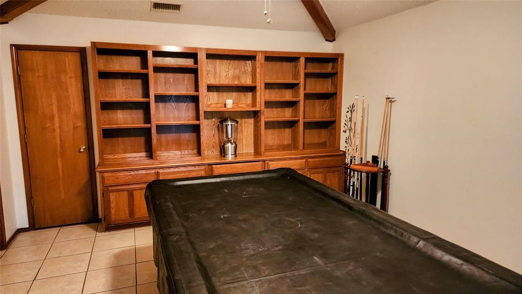 7505 Patsy Court Arlington, TX 76016 - Photo 9 of 38 Game Room with beamed ceiling, light tile patterned floors, built -in shelves, and included billiards table.