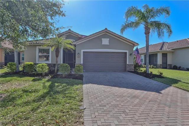 a front view of a house with a yard and palm trees