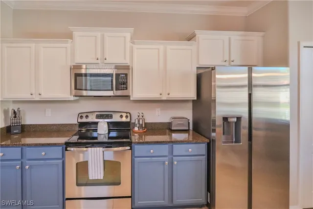 a kitchen with refrigerator a microwave a stove and cabinets