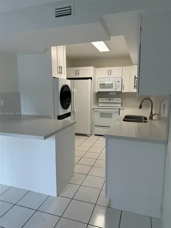 a kitchen with a sink a stove and a refrigerator