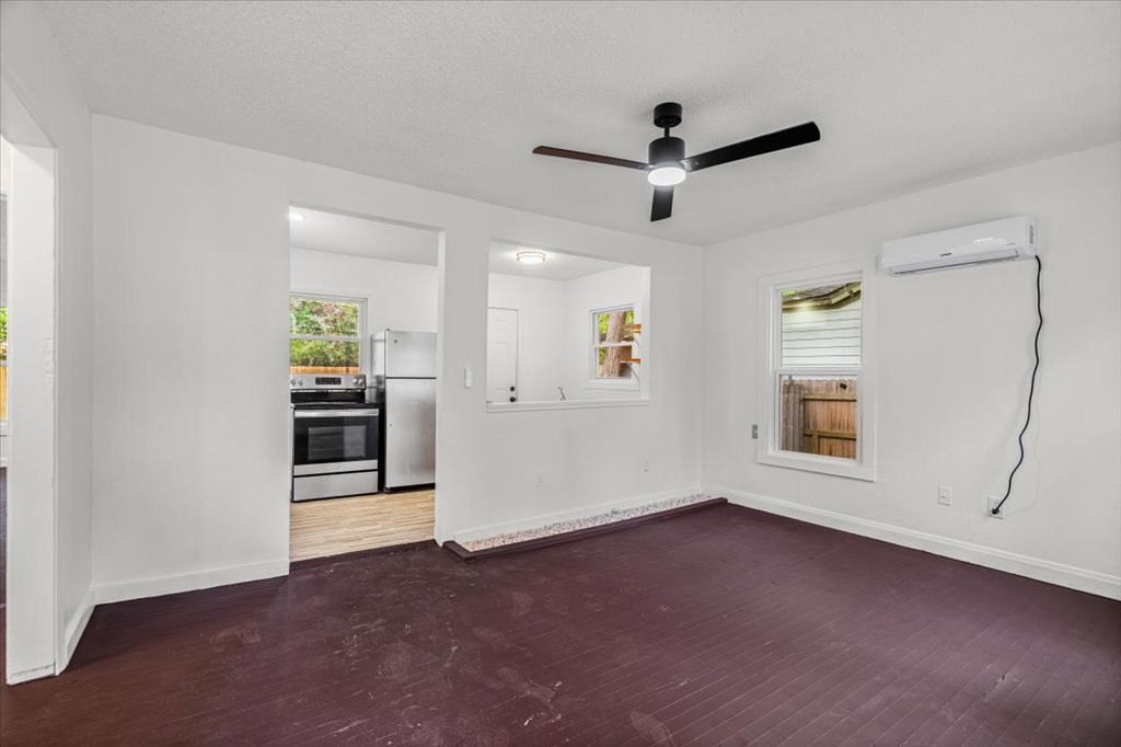 2206 Rountree Drive Austin, TX 78722 - Photo 2 of 16 Unfurnished room featuring dark wood-type flooring, a ceiling fan, and a textured ceiling