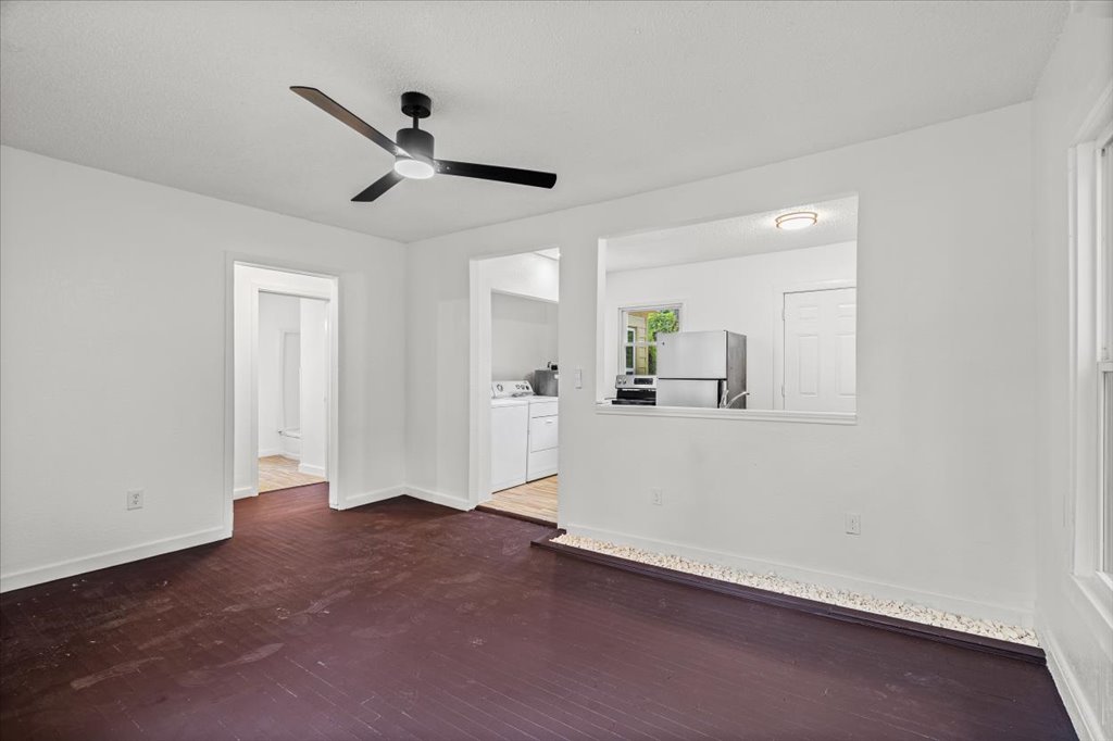 2206 Rountree Drive Austin, TX 78722 - Photo 4 of 16 Unfurnished living room with separate washer and dryer, a ceiling fan, and dark wood finished floors