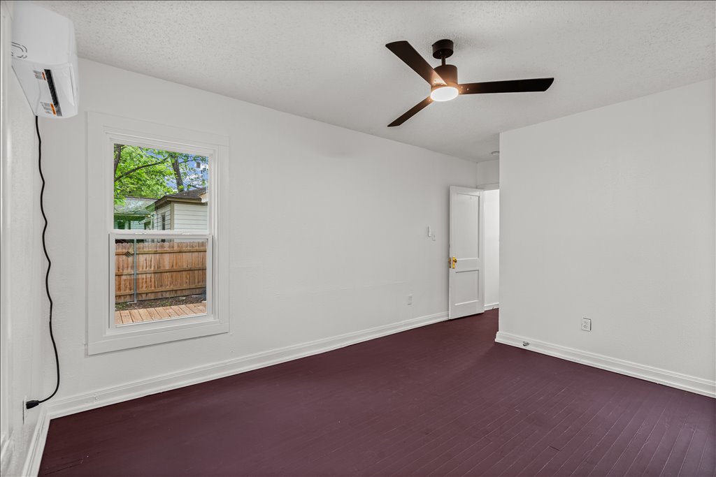 2206 Rountree Drive Austin, TX 78722 - Photo 9 of 16 Unfurnished room featuring dark wood-style floors, a textured ceiling, and a ceiling fan