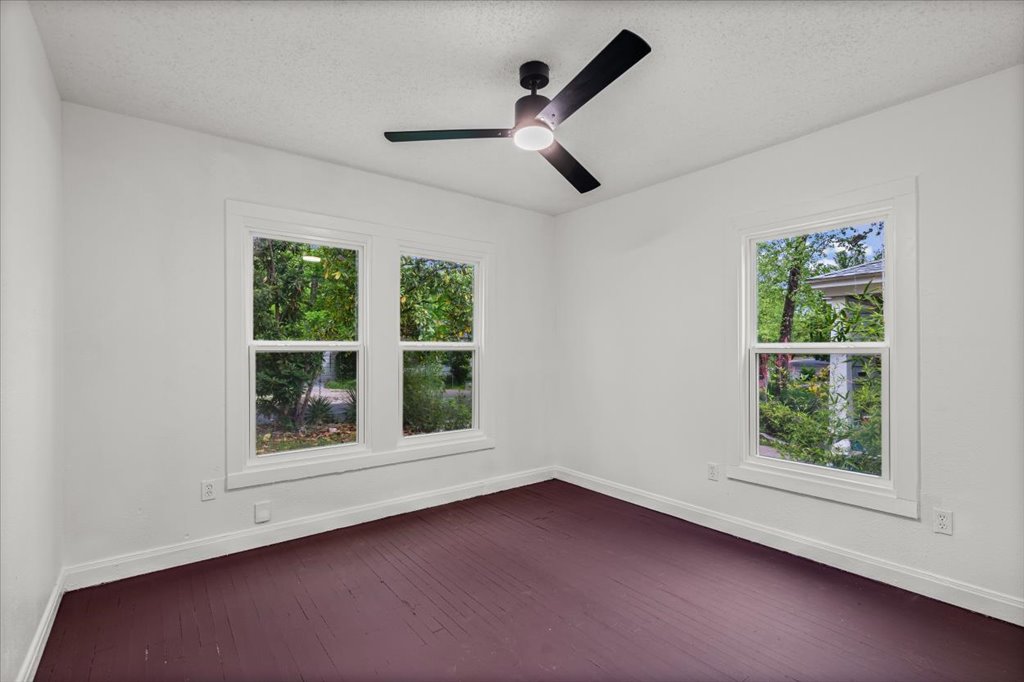 2206 Rountree Drive Austin, TX 78722 - Photo 10 of 16 Spare room featuring a textured ceiling, dark wood-type flooring, and ceiling fan