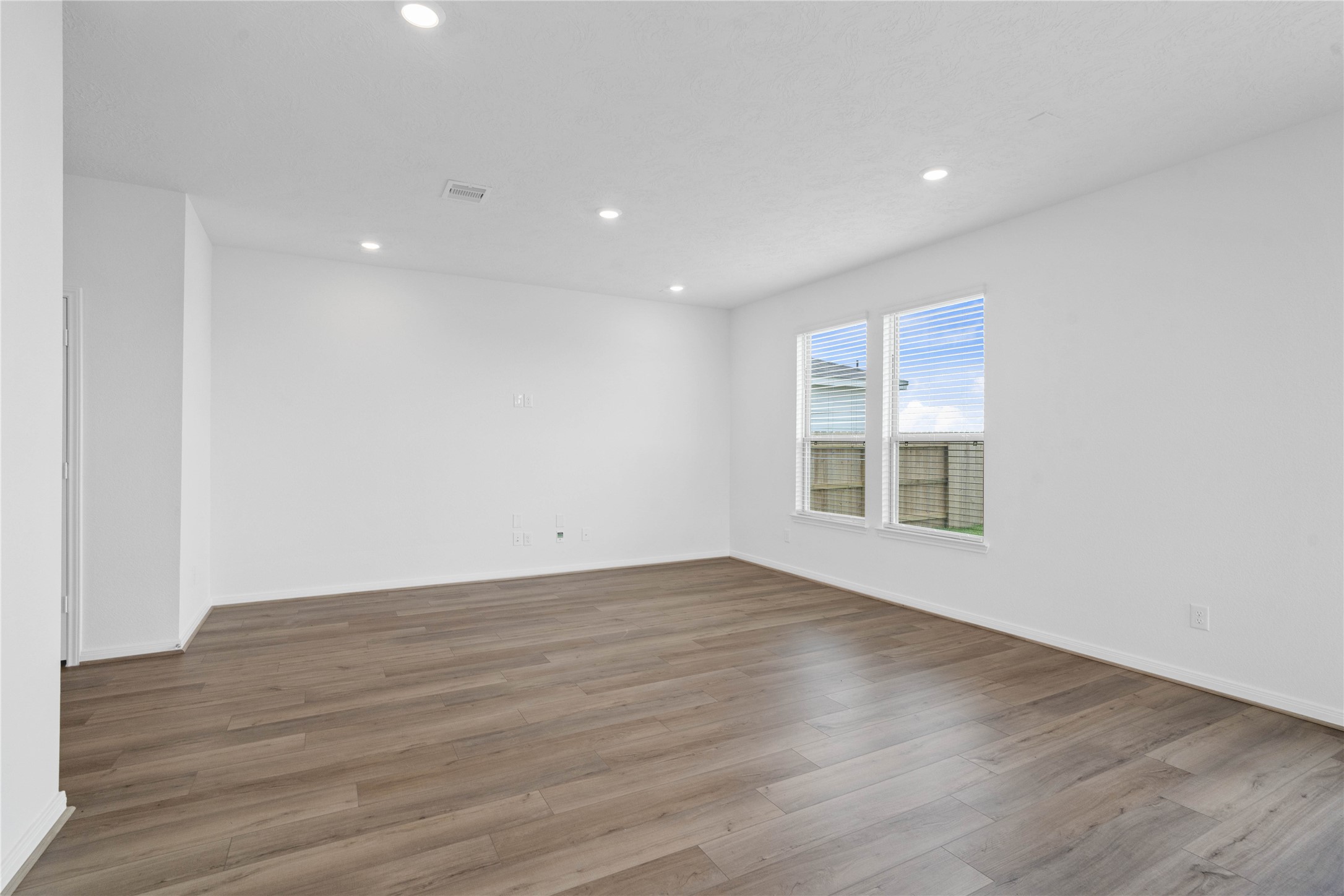 7210 Brooklea Road Beasley, TX 77417 - Photo 9 of 32 Bring family and friends together in this beautiful family room! It features high ceilings, recessed lighting, custom paint, stunning vinyl plank flooring, and large windows with fitted blinds!