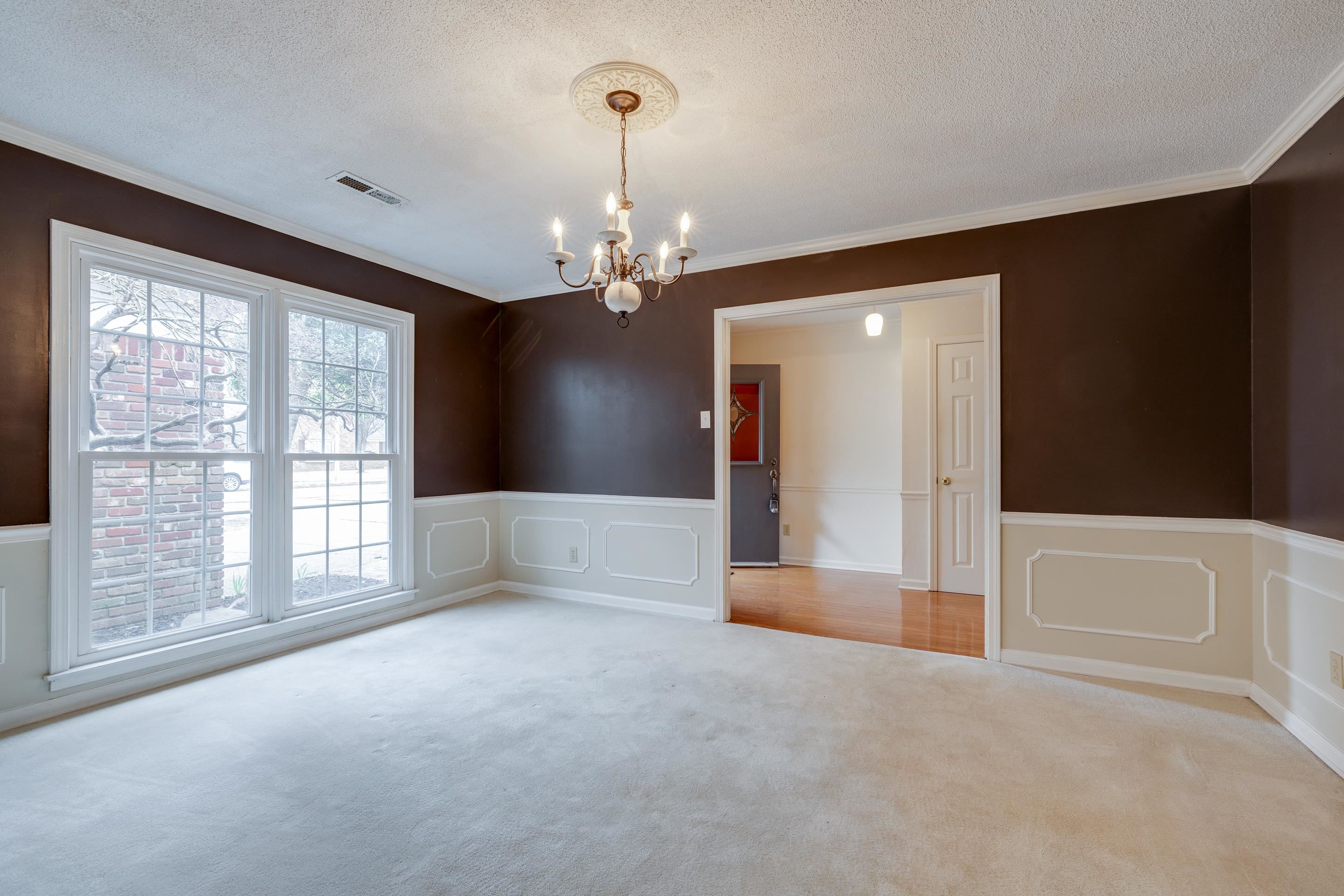 3523 County Gate Road Memphis, TN 38119 - Photo 3 of 30 Empty room featuring visible vents, ornamental molding, carpet floors, and a notable chandelier