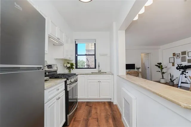 a kitchen with granite countertop a sink stove and refrigerator