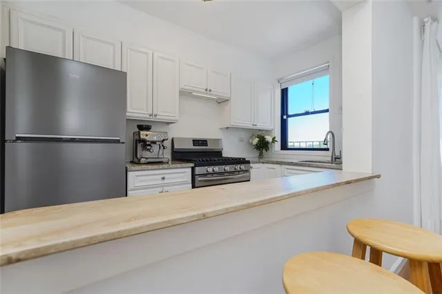 a kitchen with stainless steel appliances a refrigerator and a stove top oven