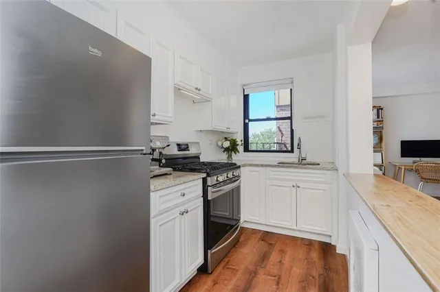 a kitchen with a sink stove top oven and cabinets