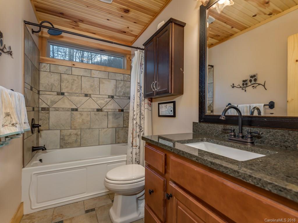 2189 Judes Gap Road Mill Spring, NC 28756 - Photo 11 of 22 a bathroom with a granite countertop bathtub sink vanity mirror and toilet