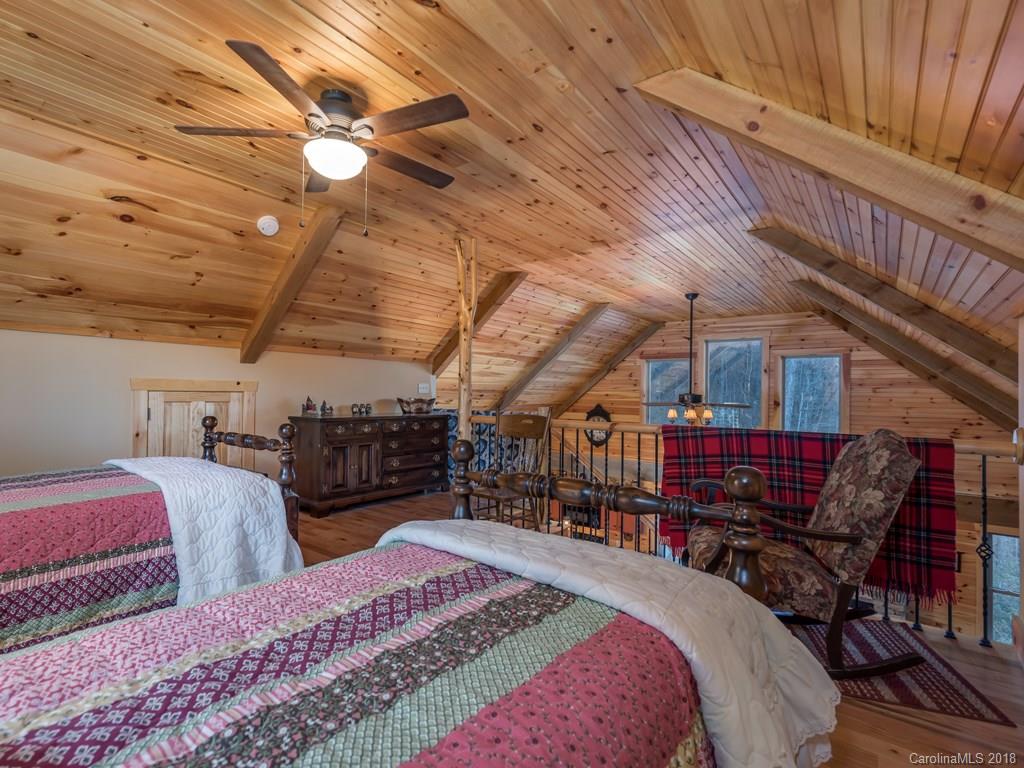 2189 Judes Gap Road Mill Spring, NC 28756 - Photo 13 of 22 a bed room with a bed a chair and a chandelier