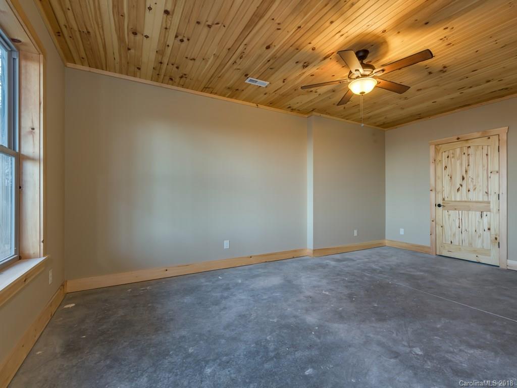 2189 Judes Gap Road Mill Spring, NC 28756 - Photo 16 of 22 en empty room with windows and chandelier fan