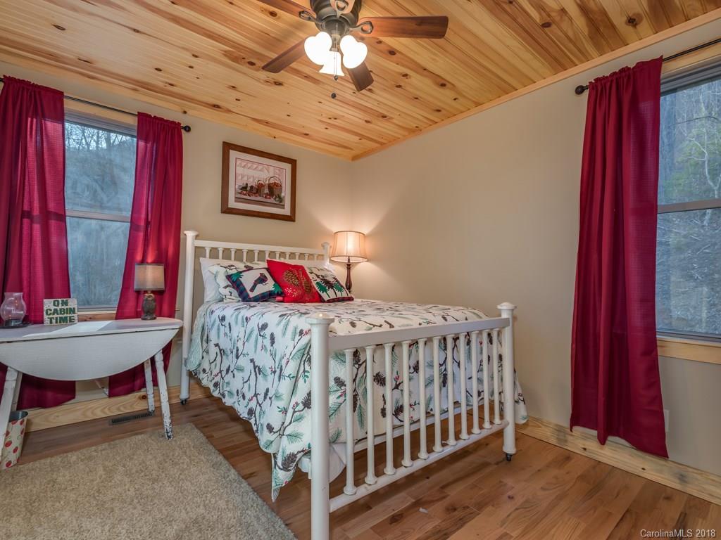 2189 Judes Gap Road Mill Spring, NC 28756 - Photo 9 of 22 a bedroom with a bed and a chandelier