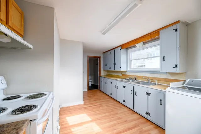 a kitchen with granite countertop a sink and a stove next to a window