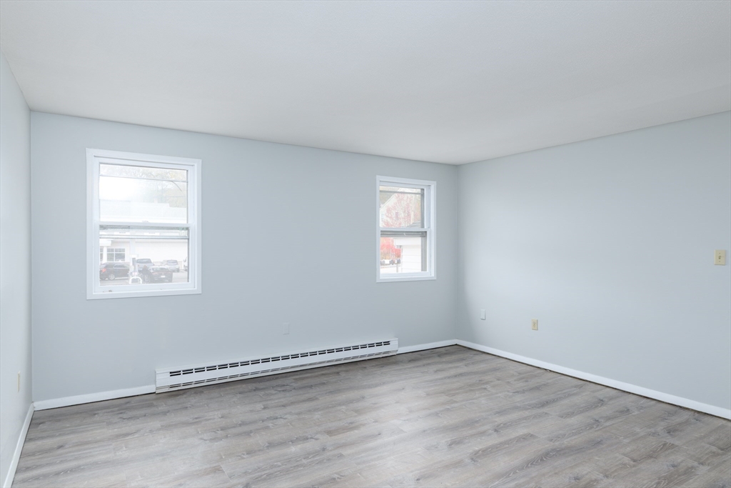 504 Main Street Sturbridge, MA 01518 - Photo 9 of 25 an empty room with wooden floor and windows