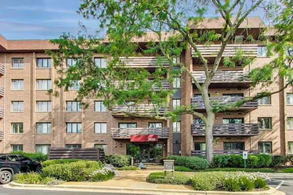 a front view of a multi story building with yard